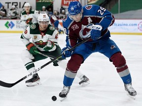 Avalanche forward Nathan MacKinnon controls the puck against Samuel Girard of the Wild during the third period of a game at Xcel Energy Center in St. Paul, Minn., Jan. 30, 2021.