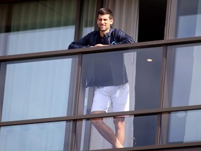 Novak Djokovic is seen on his hotel balcony, in North Adelaide, Australia, Jan. 28, 2021.