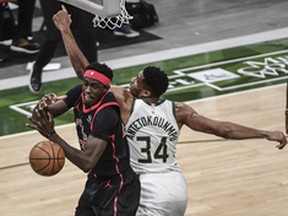 Bucks forward Giannis Antetokounmpo (right) and Raptors forward Pascal Siakam battle for a rebound in Milwaukee on Tuesday night.