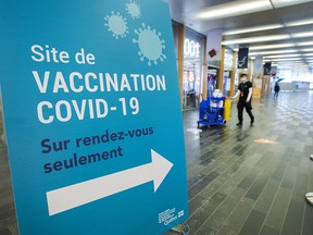 A cleaner walks through the empty halls of one of the mass COVID-19 vaccination sites as the wait for more doses to arrive continues Tuesday, February 9, 2021 in Montreal.