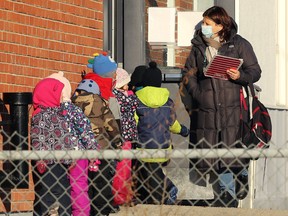 Children queue to return indoors at John Dafoe School in Winnipeg, Dec. 2, 2020.