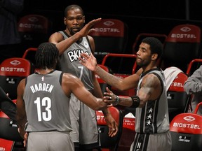 James Harden (left), Kevin Durant (top), and Kyrie Irving of the Brooklyn Nets high-five during an NBA game on Jan. 25, 2021.