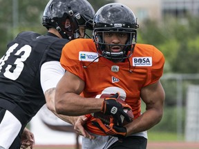 John White, then of the BC Lions, takes a handoff from quarterback Mike Reilly at the team's 2019 Training Camp. White has joined the Toronto Argonauts as a free agent.