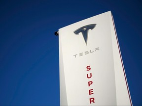 In this file photo taken on Jan. 4, 2021 a Tesla logo is seen on signage at a Tesla Inc. supercharger station in Hawthorne, Calif.