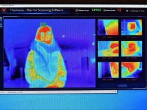 The results of a a thermal imaging camera are displayed on a screen as a person waits at the reception desk at the St. Giles Hotel near Heathrow Airport in west London, on Feb. 10, 2021.