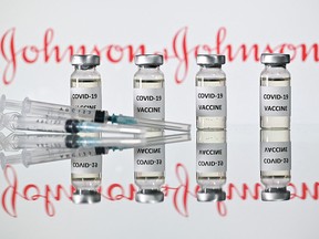Vials with COVID-19 vaccine stickers attached and syringes with the logo of U.S. pharmaceutical company Johnson & Johnson.