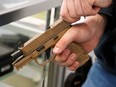 A worker clears a handgun for a customer at Davidson Defense in Orem, Utah on February 4, 2021.