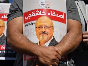 In this file photo taken on October 02, 2020, friends of murdered Saudi journalist Jamal Khashoggi hold posters bearing his picture as they attend an event marking the second-year anniversary of his assassination in front of Saudi Arabia Istanbul Consulate.
