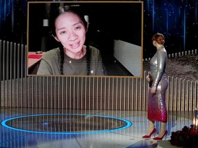 This handout photo courtesy of NBCUniversal shows Chloe Zhao (on screen) accepting the Best Director - Motion Picture award for "Nomadland" via video from Bryce Dallas Howard onstage at the 78th Annual Golden Globe Awards held at the Rainbow Room on February 28, 2021