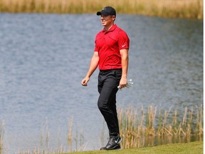 Rory McIlroy walks to the second green wearing red and black honoring Tiger Woods during the final round of World Golf Championships at The Concession golf tournament at The Concession Golf Club.