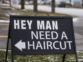 A sign pointing to Chrome Artistic Barbering in St. Catharines, Ont., Jan. 20, 2021.