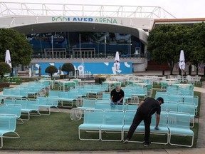 Workers clean a seating area at Melbourne Park in the wake of the day's tennis matches leading up to the Australian Open being cancelled after a hotel quarantine worker at a player hotel tested positive for the coronavirus disease (COVID-19) in Melbourne, Australia, February 4, 2021.