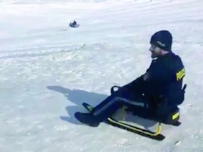 OPP Const. Fontaine takes a ride down a toboggan hill in Wasaga Beach.