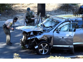 Los Angeles County Sheriff's Deputies inspect the vehicle of golfer Tiger Woods, who was rushed to hospital after suffering multiple injuries, after it was involved in a single-vehicle accident in Los Angeles.