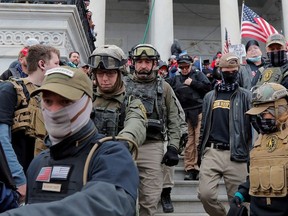 Jessica Marie Watkins  (2nd from L) and Donovan Ray Crowl (Center), both from Ohio, march down the east front steps of the U.S. Capitol with the Oath Keepers militia group among supporters of U.S. President Donald Trump in Washington, U.S., January 6, 2021.