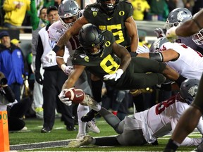 Jevon Holland of the Oregon Ducks dives for a 19-yard pick six against the Washington State Cougars.