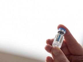 Health Department employee Janet Gerber holds the first vial of the Janssen COVID-19 vaccine at Louisville Metro Health and Wellness headquarters on March 4, 2021 in Louisville, Kentucky.