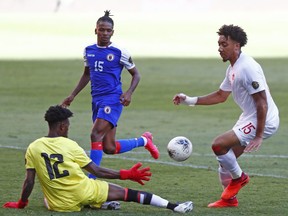 Thelonius Bair (15) of Canada is stopped by Haiti goalkeeper Alan Jerome as defender Denilson Pierre (15) looks on at CONCACAF Men's Olympic Qualifying at Akron Stadium in Zapopan, Mexico on March 22, 2021.