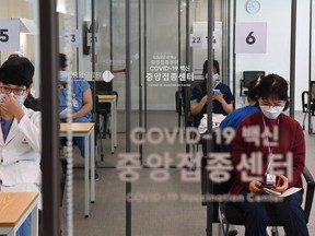 Medical workers wait to receive the first dose of the Pfizer BioNTech vaccine Covid-19 at the National Medical Center vaccination center on February 27, 2021 in Seoul, South Korea. South Korea started its first inoculation program against the new coronavirus over one year after its first confirmed case, as health authorities hope to attain herd immunity by November.