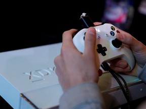 In this file photo taken on Nov, 5, 2017, a gamer plays video games with an Xbox console during the 2017 Paris Games Week exhibition at the Porte de Versailles exhibition centre in Paris.
