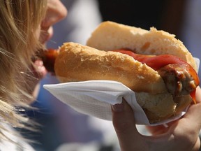 Visitors eat bratwurst sausages on German Unity Day (Tag der Deutschen Einheit) on October 3, 2014 in Berlin, Germany.