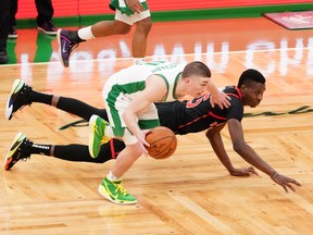 Celtics' Payton Pritchard (left) works the ball against Raptors' Chris Boucher during the third quarter at TD Garden in Boston on Thursday, March 4, 2021.