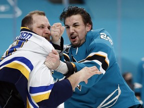Kurtis Gabriel (right) tangles with Kyle Clifford of the Blues, one of three fights the Sharks' recently recalled tough guy has engaged in during his four games up.