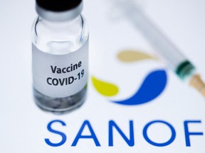 A bottle reading "Vaccine COVID-19" next to French biopharmaceutical company Sanofi logo.