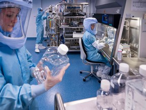 Employees in cleanroom suits test the procedures for the manufacturing of the messenger RNA (mRNA) for the COVID-19 vaccine at the new manufacturing site of German company BioNTech on March 27, 2021 in Marburg, central Germany.