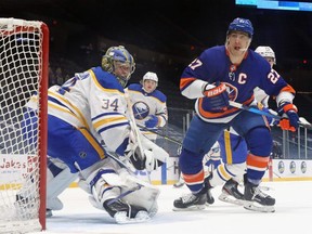 Anders Lee, right, of the Islanders skates against Jonas Johansson of the Sabres at the Nassau Coliseum on March 7, 2021 in Uniondale, N.Y.