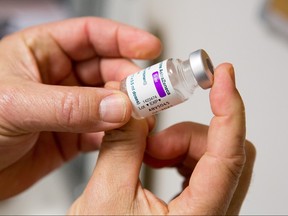 In this file photo taken on Feb. 26, 2021 a vial of the AstraZeneca COVID-19 vaccine is received by Dr Jean Louis Bensoussan, a general practitioner in Gragnague near Toulouse in the south of France.