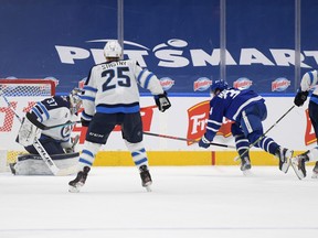 Maple Leafs' Auston Matthews scores the winning goal in overtime past Winnipeg Jets goalie Connor Hellebuyck (at Scotiabank Arena on Thursday, March 11, 2021.