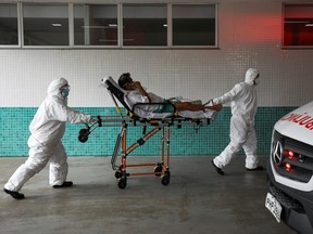 Health workers transport a man, who, according to his wife, is suffering with COVID-19 symptoms, at 28 de Agosto hospital, in Manaus, Brazil, Jan. 14, 2021.