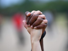 A man and a woman hold hands aloft in Hyde Park during a "Black Lives Matter" protest following the death of George Floyd who died in police custody in Minneapolis, London, Britain, June 3, 2020.