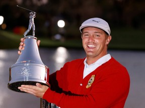 Bryson DeChambeau holds the champions trophy after winning the Arnold Palmer Invitational golf tournament at Bay Hill Club & Lodge in Orlando, Fla., March 7, 2021.