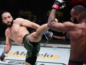 In this handout image provided by UFC, Bulal Muhammad, left, kicks Leon Edwards in a welterweight fight during the UFC Fight Night event at UFC APEX in Las Vegas, Saturday, March 13, 2021.