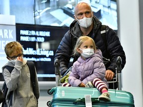 Travellers, wearing masks, arrive on a direct flight from China, at Vancouver International Airport in Richmond, B.C. January 24, 2020.