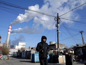 A man walks near a coal-fired power plant in Harbin, Heilongjiang province, China on November 27, 2019.
