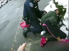 This image taken by body camera video shows a Rochester, police officer struggling to subdue a woman suspected of shoplifting who tried to escape with her 3-year-old child in her arms on Feb. 22, 2021.