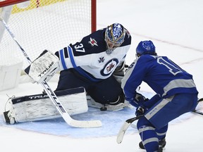 Winnipeg Jets goaltender Connor Hellebuyck makes a save on a breakaway against Maple Leafs' Mitch Marner during the third period in Toronto on Tuesday, March 9, 2021.