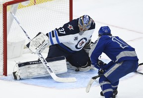 Winnipeg Jets goaltender Connor Hellebuyck makes a save on a breakaway against Maple Leafs' Mitch Marner during the third period in Toronto on Tuesday, March 9, 2021.