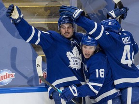 Maple Leafs' Auston Matthews (left) is congratulated by teammates Mitch Marner ((centre) and Morgan Rielly after scoring the game-winning goal during overtime against the Winnipeg Jets in Toronto on Thursday, March 11, 2021.