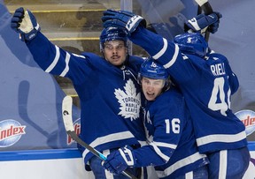 Maple Leafs’ Auston Matthews (left) is congratulated by teammates Mitch Marner (centre) and Morgan Rielly after scoring the game-winning goal during overtime against the Winnipeg Jets in Toronto on Thursday, March 11, 2021.