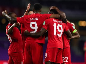 Canada striker Cyle Larin (9) celebrate with Alphonso Davies (19) and teammates after scoring against Bermuda in a 2022 FIFA World Cup Qualifying game in Orlando, Fla., on March 25, 2021.