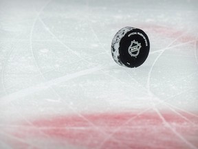A view of a puck and the NHL logo and the face-off circle at the American Airlines Center.