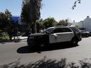 A police car stands at the site where Lady Gaga's dog walker was shot and two of her dogs were stolen in Los Angeles February 25, 2021. 