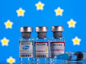 Vials with Pfizer-BioNTech, AstraZeneca, and Moderna COVID-19 vaccine labels are seen in front of a European Union flag in this illustration picture taken March 19, 2021.