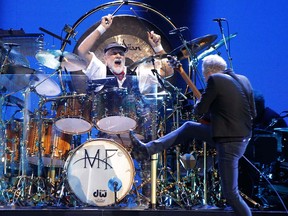 Lindsey Buckingham cavorts in front of drummer Mick Fleetwood of Fleetwood Mac at the Scotiabank Saddledome in Calgary on Friday November 14, 2014.