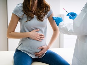 A pregnant woman receiving a shot.