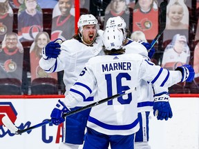 Maple Leafs' Justin Holl (left) celebrates his overtime winner against the Senators with teammates Mitch Marner and Auston Matthews on Thursday, March 25, 2021 at the Canadian Tire Centre in Ottawa.